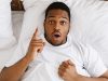 African American Man Having Idea Lying In Bed At Home